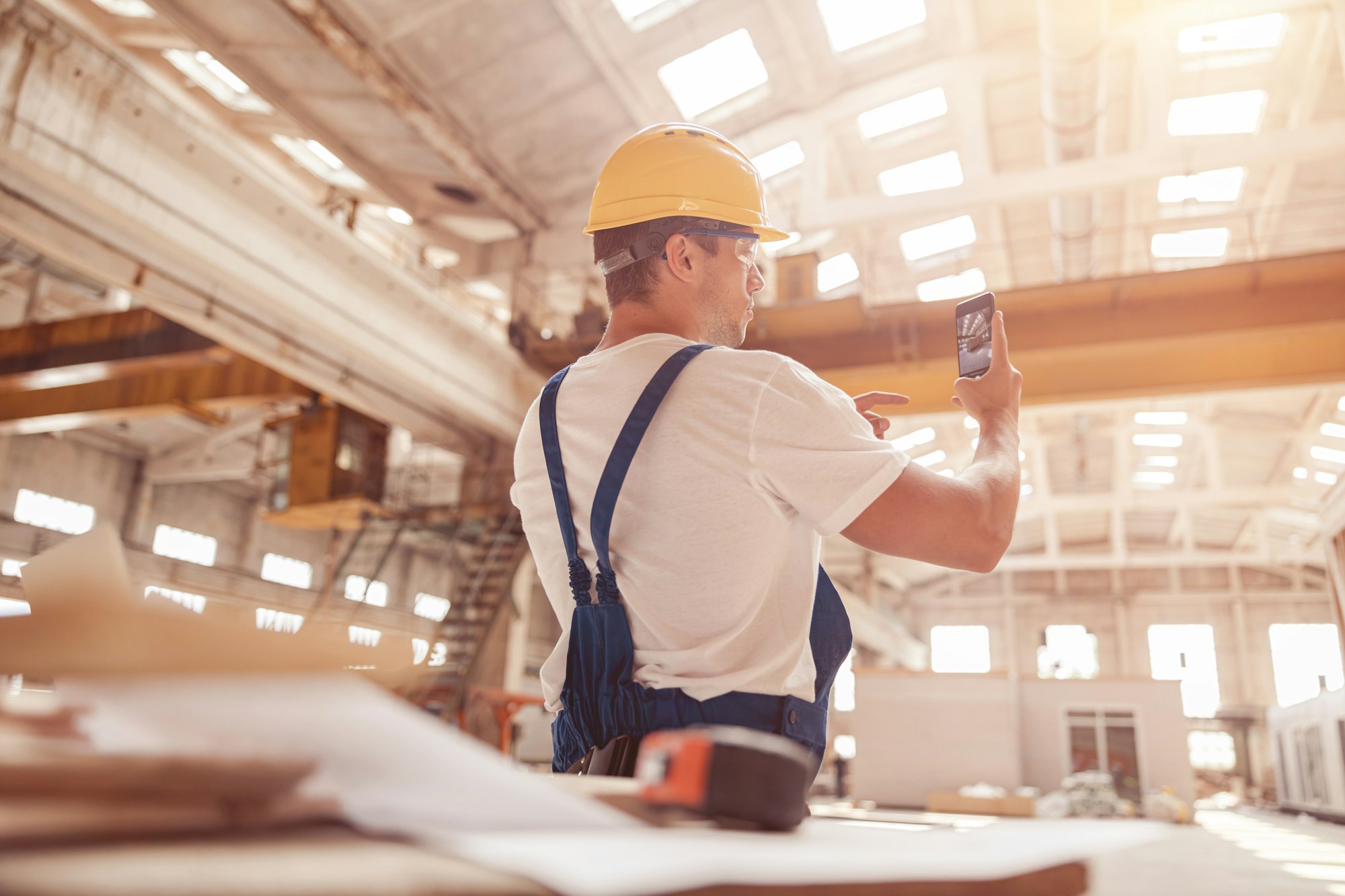 Male worker taking building photo with modern smartphone